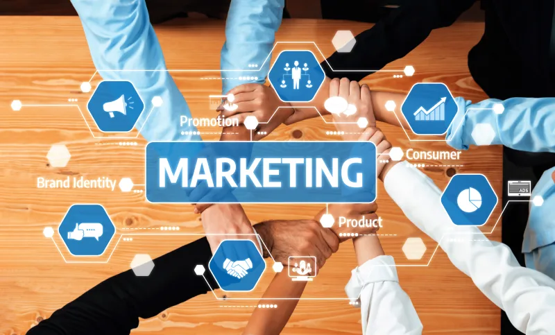 Aerial view of a group of people forming a circle with their hands, overlaid with a digital graphic of various marketing terms and icons.